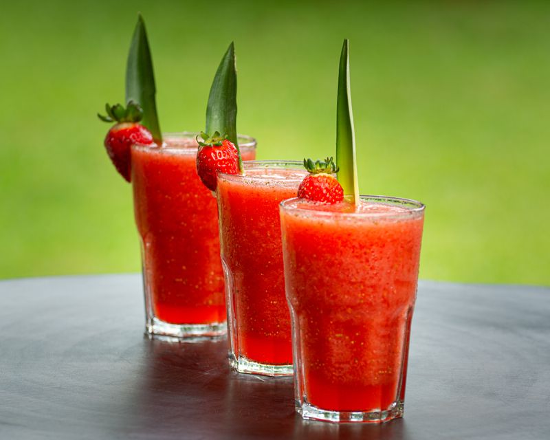 Tre bicchieri di gazpacho di fragole guarniti con una fragola